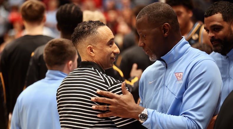 Dayton's Anthony Grant, right, and Marquette's Shaka Smart shake hands before the game on Saturday, Dec. 14, 2024, at UD Arena. David Jablonski/Staff