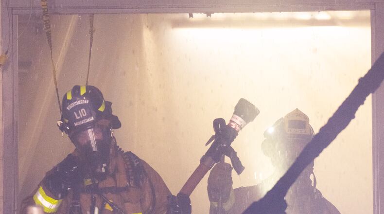 Firefighters with the 788th Civil Engineer Squadron Fire Department, work in the smoke, steam and water of a room on fire July 18 in building 18, on Area B, Wright-Patterson Air Force Base. Fifteen firefighters from the Wright-Patt Fire Department and 4 firefighters from the City of Riverside Fire Department responded to the alert. (Air Force photo by R.J. Oriez)