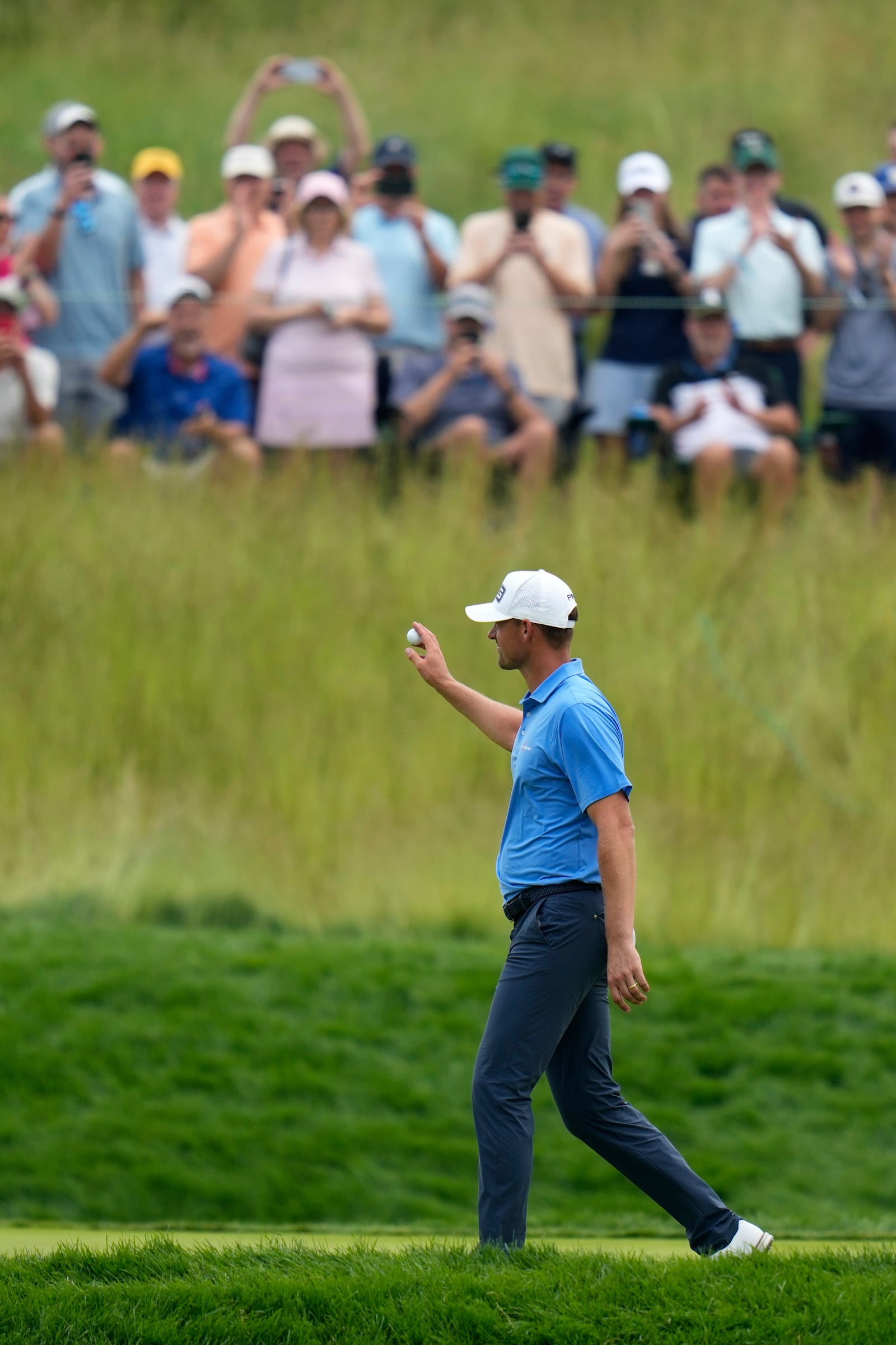 Victor Perez, of France, acknowledges fans as he walks up to the seventh tee after making a hole in one on the sixth hole during the second round of the U.S. Open golf tournament at Oakmont Country Club Friday, June 13, 2025, in Oakmont, Pa. (AP Photo/Seth Wenig)