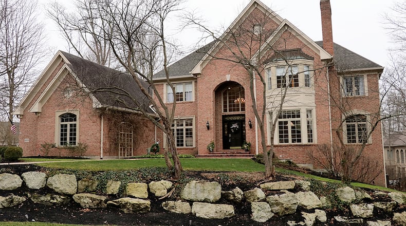 The 4-bedroom home with about 6,470 sq. ft. of living space sits on a corner lot with stone accented tree islands, a paver-brick driveway and sculptured gardens. CONTRIBUTED PHOTO BY KATHY TYLER