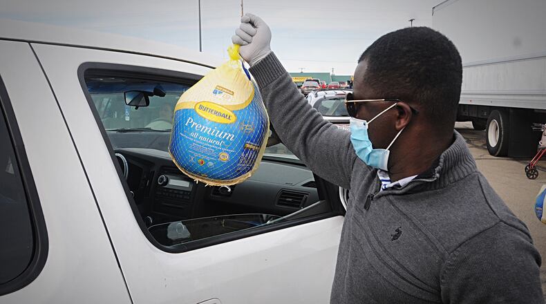 FILE PHOTO The old Kroger parking lot on Needmore Road looks like a car lot has people lineup to receive a free turkey from the God’s Grace Food Pantry. MARSHALL GORBY\STAFF