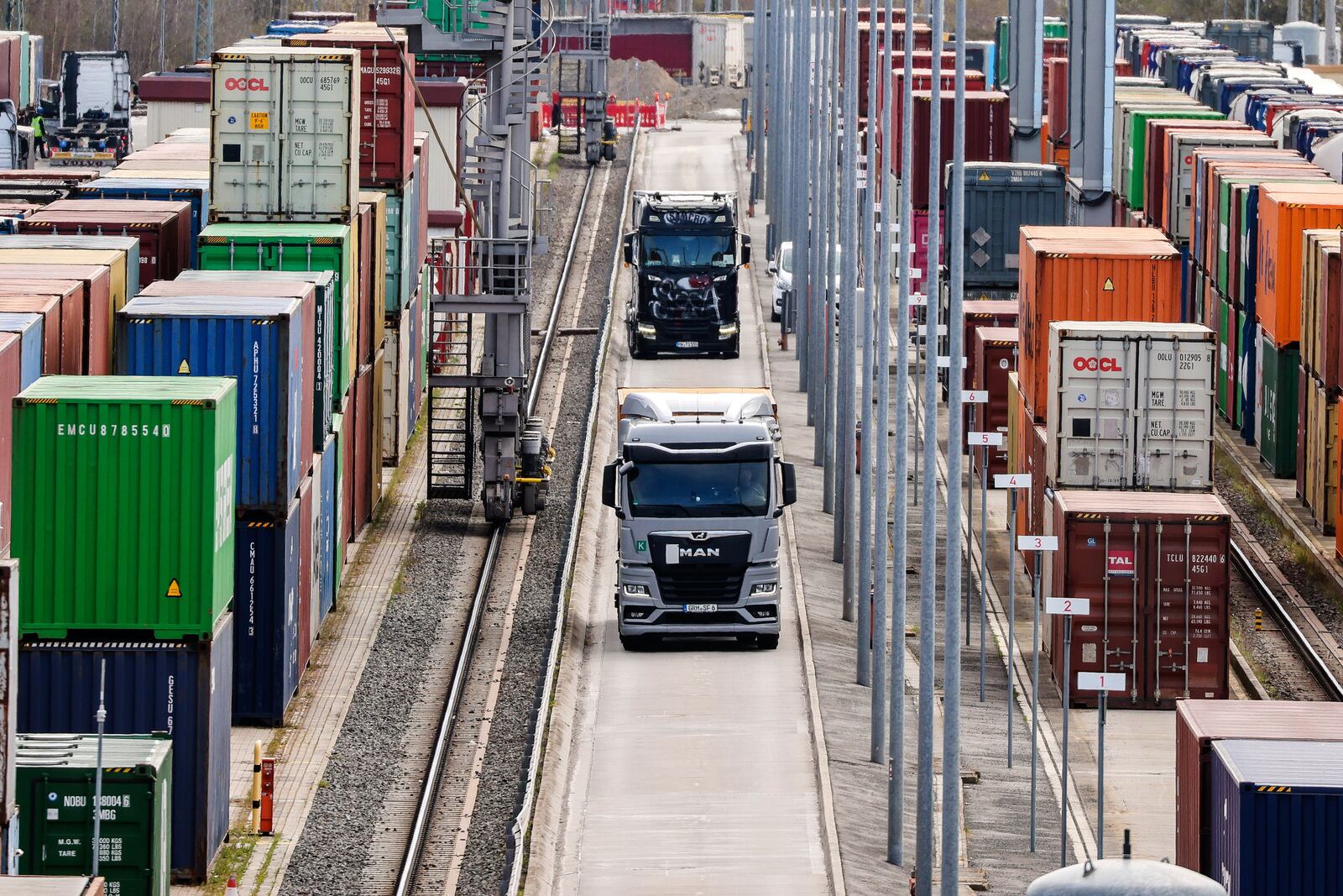 Trucks with containers drive through a logistic-terminal in Leipzig, Germany, Monday, April 7, 2025. (Jan Woitas/dpa via AP)