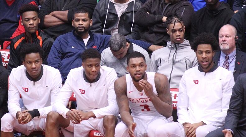 Jhery Matos, second from right in second row, watches a game against Fordham from behind the Dayton bench on Saturday, Feb. 17, 2018, at UD Arena. David Jablonski/Staff