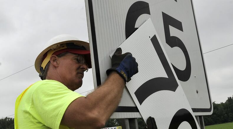 Dan Knoop, of the Ohio Department of Transportation, changes the speed limit signs along Interstate 70 in Clark County to 70 miles per hour Monday, July 1, 2013. Interstate 70 through Clark County is one of the areas in the state that has increased the speed limit from 65 to 70 mph effective July 1. Bill Lackey/Staff