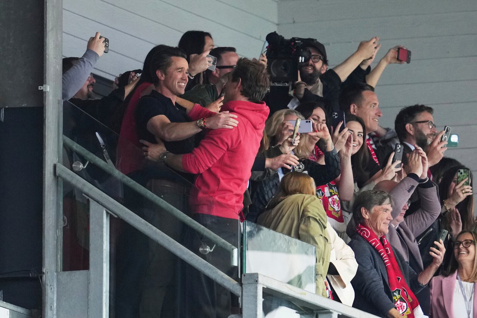 Wrexham co-owners Ryan Reynolds, center, and Rob McElhenney celebrate at the end of the English League One soccer match between Wrexham and Charlton Athletic at the Racecourse ground in Wrexham, Wales, Saturday, April 26, 2025. (AP Photo/Jon Super)