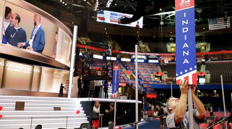 Tom Sondels makes an adjustment to the Indiana state delegation placard as preparations continue for the Republican National Convention, Friday, July 15, 2016, at the Quicken Loans Arena in Cleveland. (AP Photo/Alex Brandon)