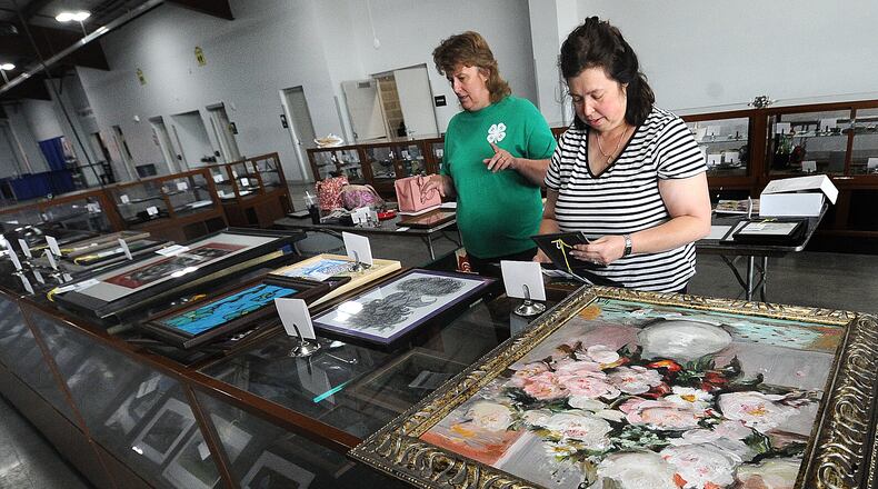 Linda Rowley, left and Leah Sax were busy Friday, July 7, 2023 setting up the open class fine arts display at the Montgomery County Fairgrounds. The fair opens on Sunday July 9th and runs through the 15th. MARSHALL GORBY\STAFF