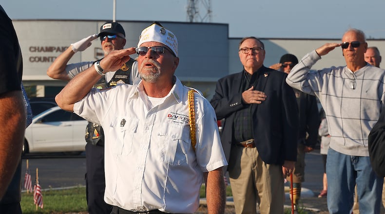 Veterans salute as the American flag is raised Monday, Sept. 11, 2023 during a 9/11 Memorial Service at Freedom Grove in Urbana. BILL LACKEY/STAFF
