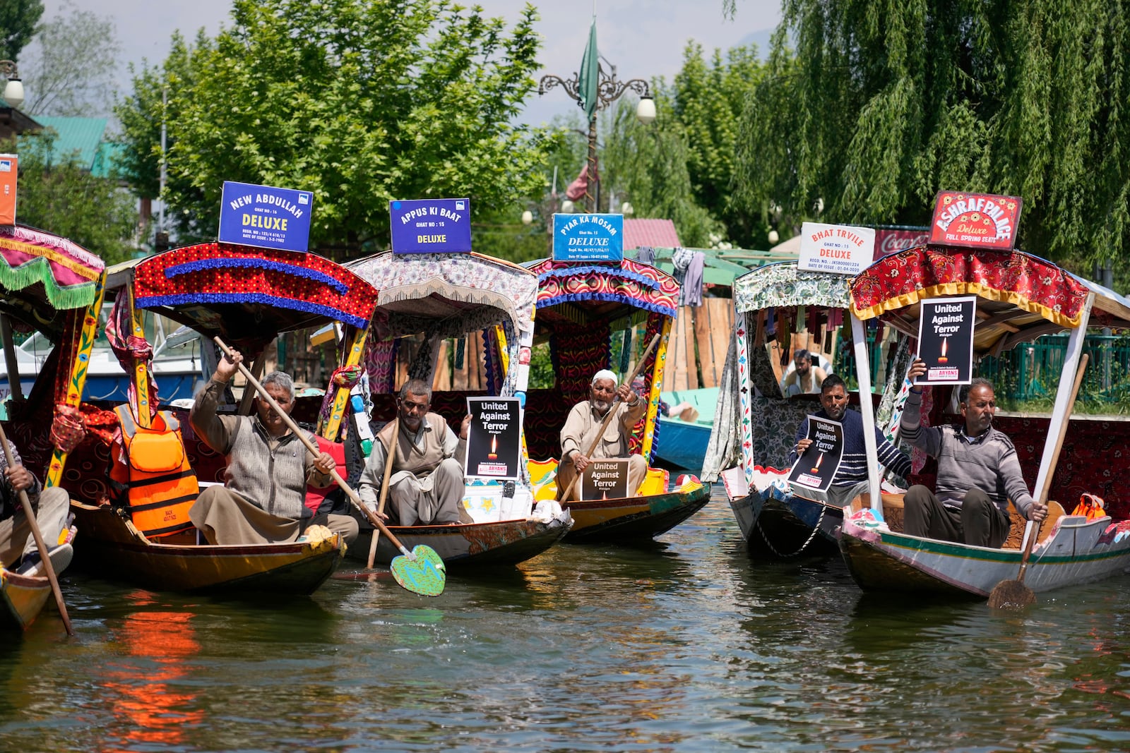 Kashmiri boatmen hold placards as they condemn the tourists killing at Dal Lake in Srinagar, Indian controlled Kashmir, Thursday, April. 24, 2025. (AP Photo/Mukhtar Khan)
