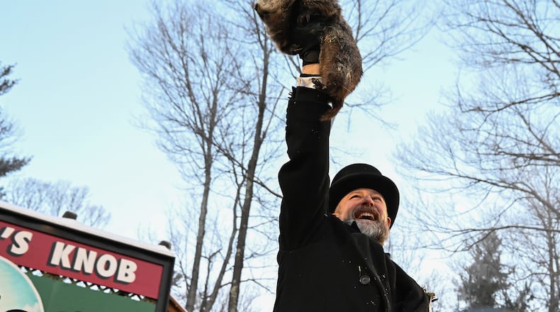 Groundhog Club handler A.J. Dereume holds Punxsutawney Phil, the weather prognosticating groundhog, during the 140th celebration of Groundhog Day on Gobbler's Knob in Punxsutawney, Pa., Monday, Feb. 2, 2026. Phil's handlers said that the groundhog has forecast six more weeks of winter. (AP Photo/Barry Reeger)