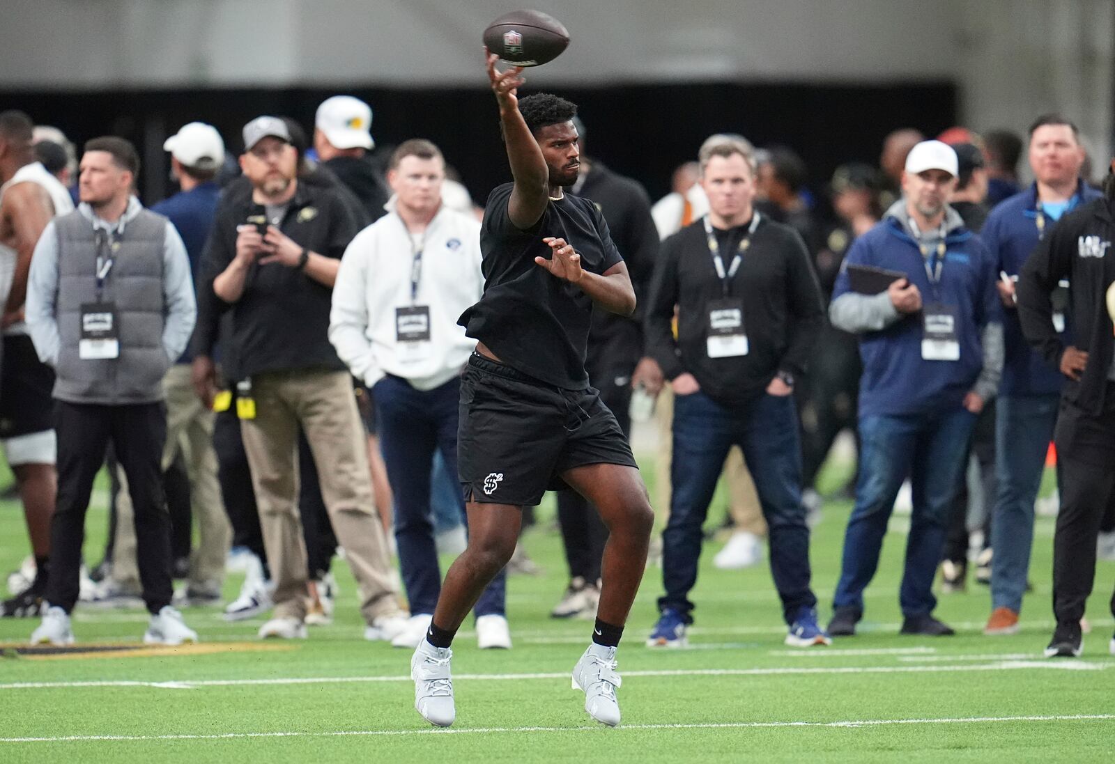 NFL scouts look on as Colorado quarterback Shedeur Sanders takes part in passing drills during Colorado's NFL football pro day Friday, April 4, 2025, in Boulder, Colo. (AP Photo/David Zalubowski)
