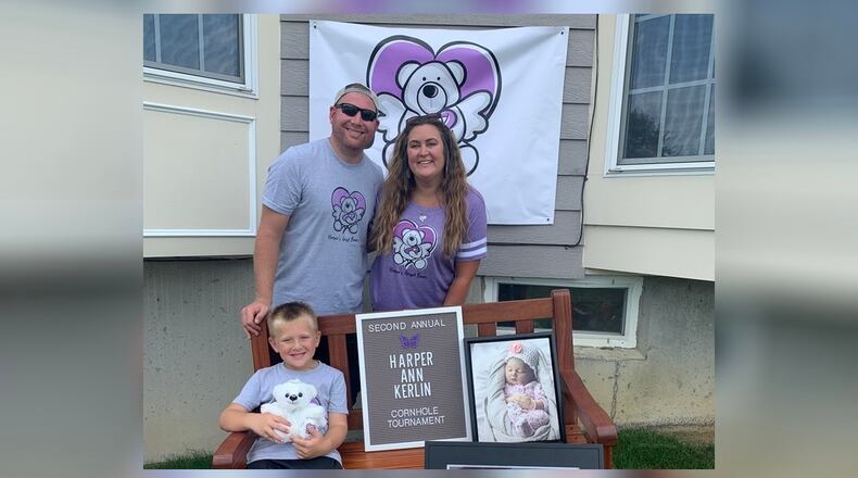 Sarah and Tyler Kerlin with their son, Jacob, pose with a photo of Harper Ann.