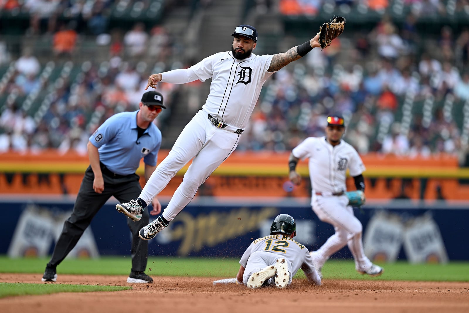 Athletics' Max Schuemann, bottom, steals second base as Detroit Tigers second baseman Gleyber Torres (25) leaps to catch the throw from catcher Jake Rogers in the third inning of a baseball game, Thursday, June 26, 2025, in Detroit. (AP Photo/Lon Horwedel)