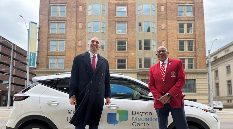 Dayton City Commissioner Matt Joseph and Mayor Jeffrey Mims Jr. show off one of the city's new all electric vehicles outside of City Hall on Friday, Dec. 2, 2022. CORNELIUS FROLIK / STAFF