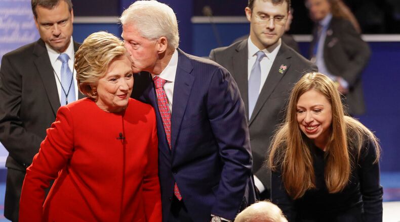Former President Bill Clinton kisses Democratic presidential nominee Hillary Clinton as she and their daughter Chelsea Clinton greet supports during the presidential debate at Hofstra University in Hempstead, N.Y., Monday, Sept. 26, 2016. (AP Photo/David Goldman)