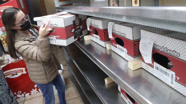 Sable Landes pulls a turkey for a customer's order Monday in the Bowman Landes store. BILL LACKEY/STAFF