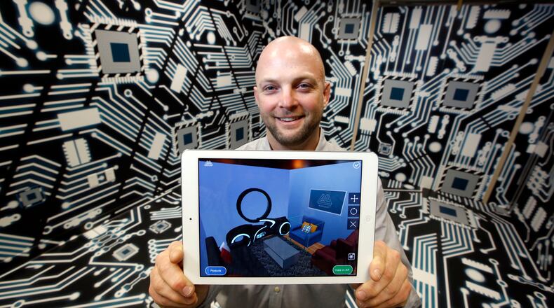 Marxent Chief Technology Officer Barry Besecker demonstrates the company s technology with an iPad in this 2015 file photo. TY GREENLEES / STAFF