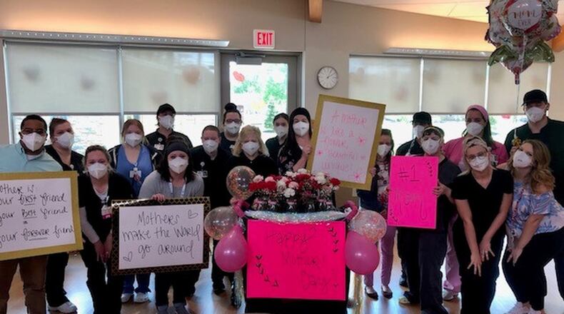 Staff help residents celebrate Mother’s Day at Jamestowne, a Hamilton senior living community by Community First Solutions. Residents at nursing homes and assisted living facilities were unable to have visitors for Mother’s Day so staff worked to help celebrate with window visits. CONTRIBUTED