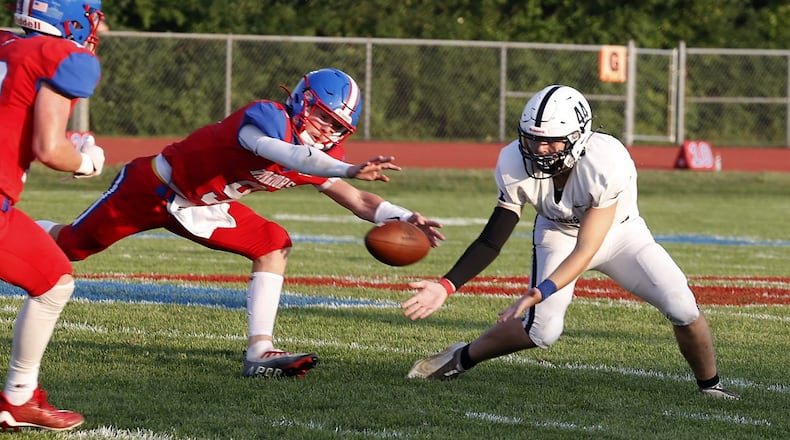 Northwestern's Riedel Smith (9) and Greenon's Peyton Travis (44) battle for a catch during Friday's game. BILL LACKEY/STAFF