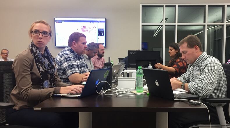 Wright State graduate student Jacqueline Gill, left, looks at a TV screen inside Wright State’s “war room” during the final presidential debate Wednesday night. Gill was working with Mike Wiehe, director of the applied policy research institute at WSU, right, and other researchers to record what was said during the debate so they could analyze reaction from Twitter in real-time. MAX FILBY / STAFF
