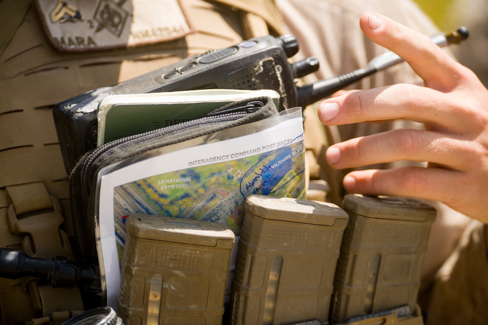 A U.S Marine adjusts their radio and outside of a federal building Friday, June 13, 2025, in Los Angeles (AP Photo/Noah Berger)