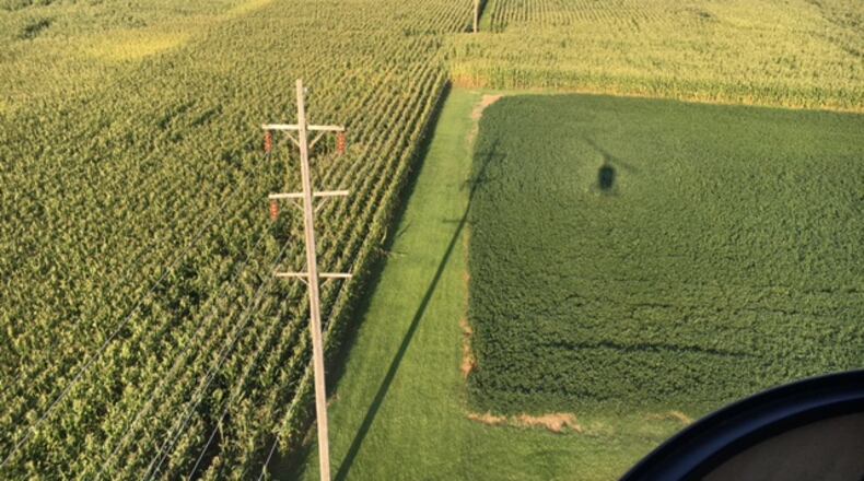 Dayton Power & Light inspectors examine sections of the utility’s 11,000 miles of power lines from a helicopter four times a year. The shadow of a DP&L helicopter can be seen in this photo, as inspectors check out lines in the Brookville area in August 2016. THOMAS GNAU/STAFF
