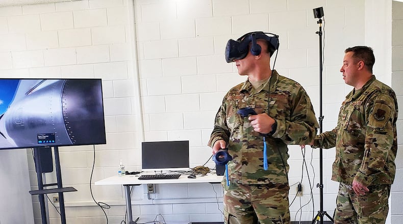Chief Master Sgt. Thomas Blount, 461st Air Control Wing command chief, virtually looks at the E-8C Joint Surveillance Target Attack Radar System aircraft as Master Sgt. Justin Ciszek, Robins Spark Hub NCO-in-charge, stands by at Robins Air Force Base, Georgia April 13. Virtual reality was brought to Team JSTARS to assist training maintainers remotely in a controlled environment. (Courtesy photo)