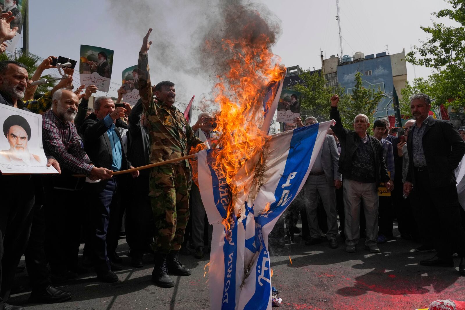 Iranian protesters burn representations of the Israeli flag during a demonstration at the Felestin (Palestine) Sq. in Tehran, Iran, Wednesday, April 9, 2025. (AP Photo/Vahid Salemi)