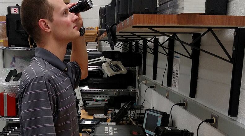 Air Force Research Laboratory Materials and Manufacturing Directorate engineer Brian Shivers helps develop and test a new visual inspection procedure to determine the difference between acceptable chafing into cold spray-applied protective coating and wear into underlying B-1 hydraulic tubing. AFRL helped develop, test and validate the cold spray coating process for the life extension of B-1 aircraft hydraulic lines. (U.S. Air Force photos/John McClure).