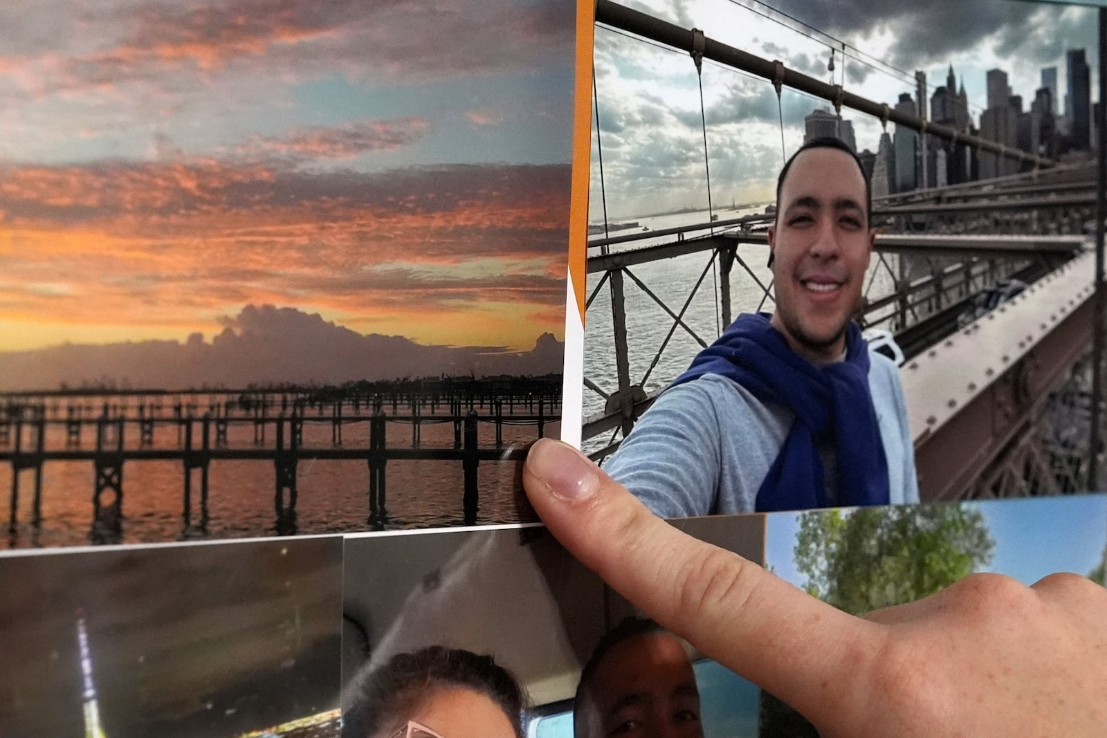 The girlfriend of Juan Serrano, a 28-year-old Colombian migrant with no criminal record who was detained Wednesday, May 21, 2025, at Miami Immigration Court after appearing for a hearing, points to a picture of the barrier island where the pair met while working on a cleanup and demolition crew following 2022's Hurricane Ian, inside their apartment in Oakland Park, Fla. (AP Photo/Rebecca Blackwell)