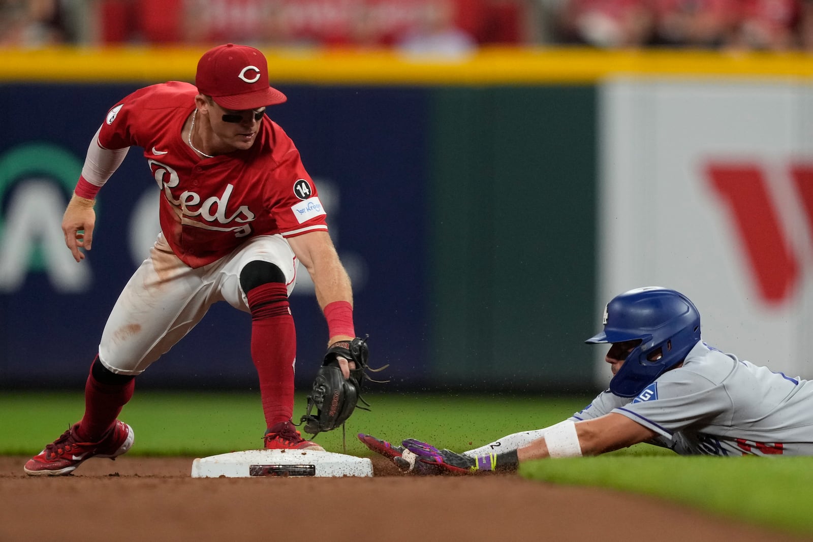Cincinnati Reds second baseman Matt McLain, left, is late with the tag as Los Angeles Dodgers Miguel Rojas is safe at second base on a double during the fifth inning of a baseball game, Monday, July 28, 2025, in Cincinnati. (AP Photo/Carolyn Kaster)