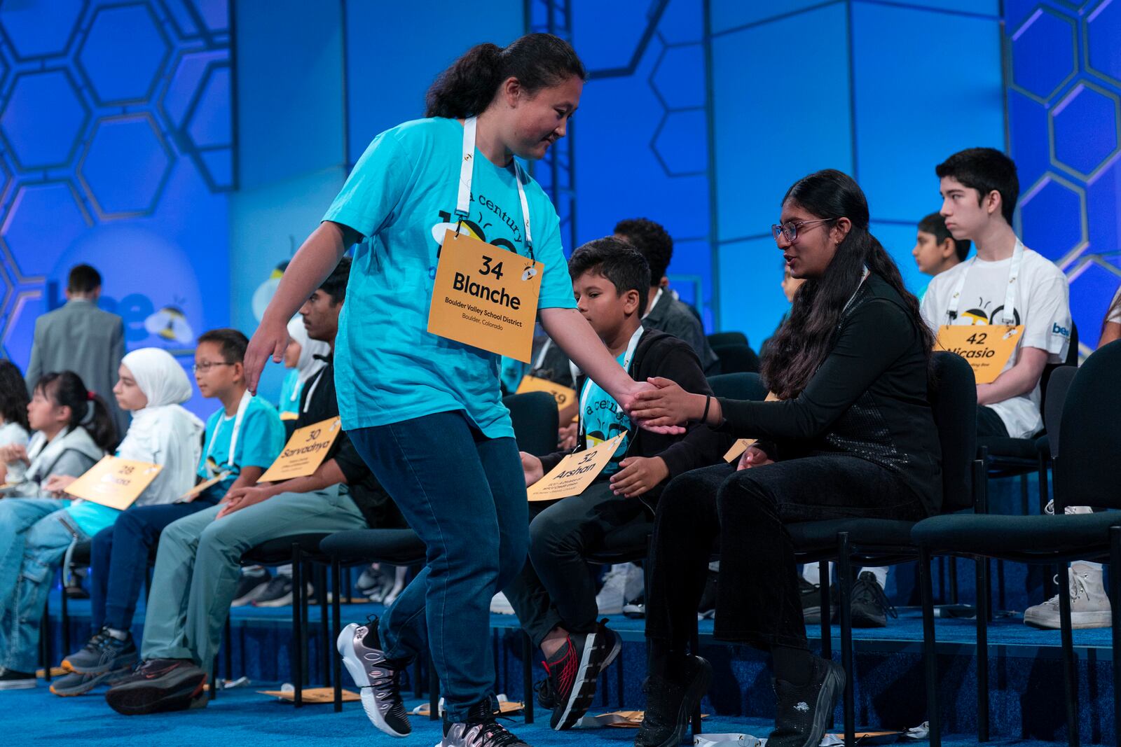 Blanche Yang Li, 14, of Boulder, Colo., high fives her friends after correctly spelling her word as she competes during the first preliminary round of the Scripps National Spelling Bee at the Gaylord National Resort & Convention Center, Tuesday, May 27, 2025, in Oxon Hill, Md. (AP Photo/Jose Luis Magana)g