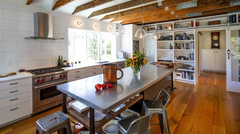 The bright, open great room is anchored by a sizable chef s table with salvaged planks underneath. It s a workhorse of function, and reads like a piece of furniture, says J.A.S. Design-Build designer Mike Freeman. The kitchen, to both of us, is a very, very important room, says homeowner Mary Speckart. We both love to cook; it s a must. And we entertain quite a bit; it s very conducive to parties. The wall at the rear closes off to the private wing of the home. (Mike Siegel/The Seattle Times/TNS)