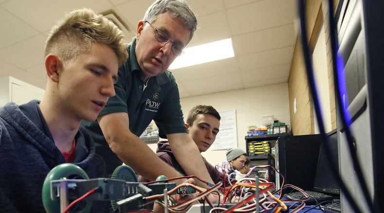 Fairborn High School physics and engineering teacher Darwin Chivers helps students Landon Hiles, left, and Devin Runge with their robotics engineering project as part of Project Lead the Way. More than 70 percent of Fairborn teachers earned the highest rating in the state evaluation system. TY GREENLEES / STAFF