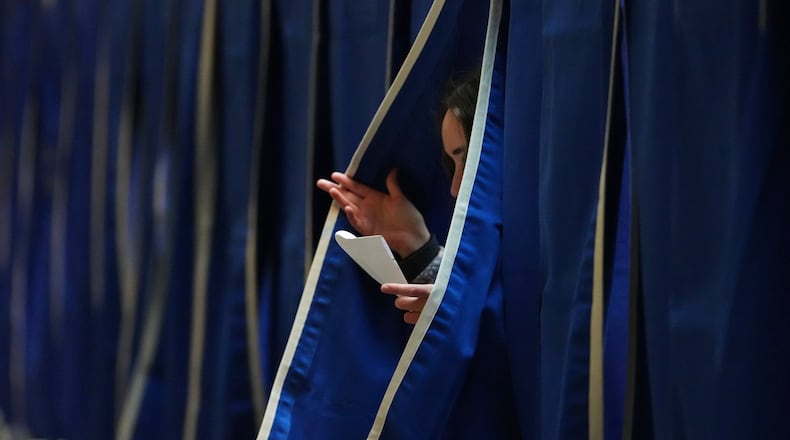 A person exits a polling booth at a polling station at City Hall in Copenhagen, Denmark, on Tuesday, March 24, 2026, during the general election. (AP Photo/Sergei Grits)