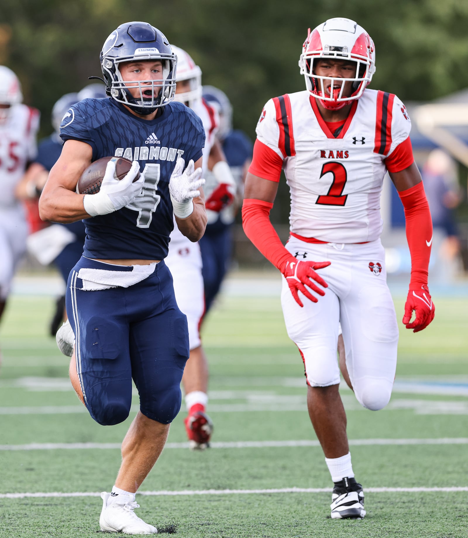 Fairmont junior running back Logan Doty runs as Trotwood-Madison's Darius Dennis pursues during a nonconference game on Friday, Aug. 29 at Roush Stadium in Kettering. BRYANT BILLING / STAFF