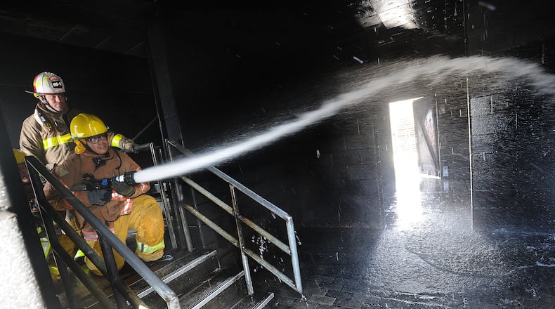 Dayton Fire Lt. John Hurst, left, instructs student, Duil Navarro, during fire training Wednesday, March 24, 2021 for the Dayton Public School District and the City of Dayton Fire/EMS CTE program. MARSHALL GORBY\STAFF