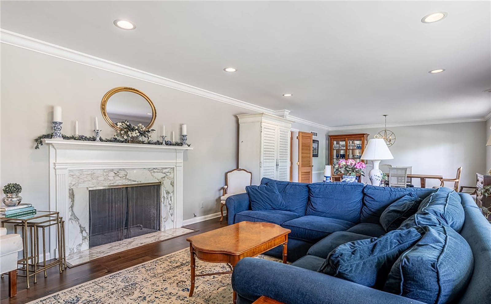 The formal living room and dining room open area has hardwood flooring and a woodburning fireplace with marble surround. CONTRIBUTED