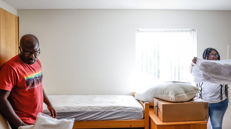 Afriyie Amoako and her father unpack boxes in her freshman dorm room Wednesday August 17 at Wright State University. JIM NOELKER/STAFF