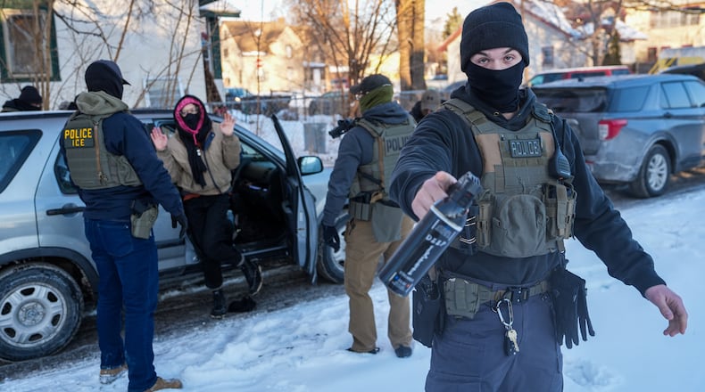 Activists are approached by federal agents for following agent vehicles, on Tuesday, Feb. 3, 2026, in Minneapolis. (AP Photo/Ryan Murphy)