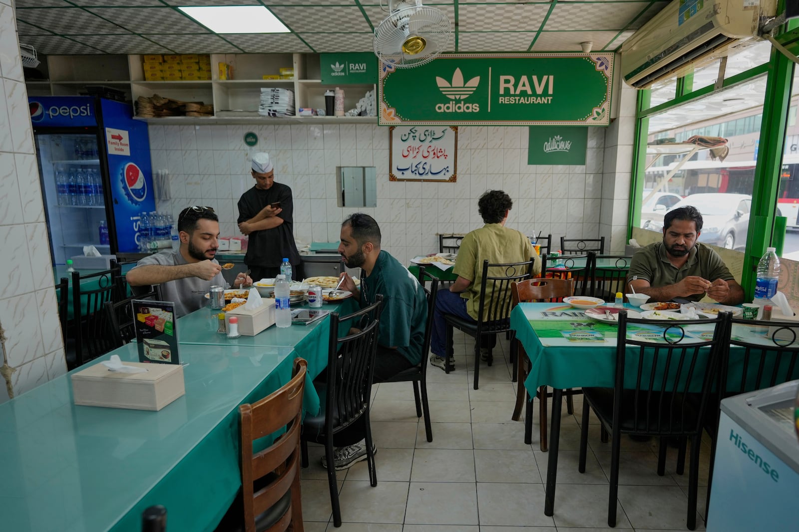 People dine at Ravi restaurant in Satwa district of Dubai, United Arab Emirates, Monday, June 9, 2025. (AP Photo/Altaf Qadri)