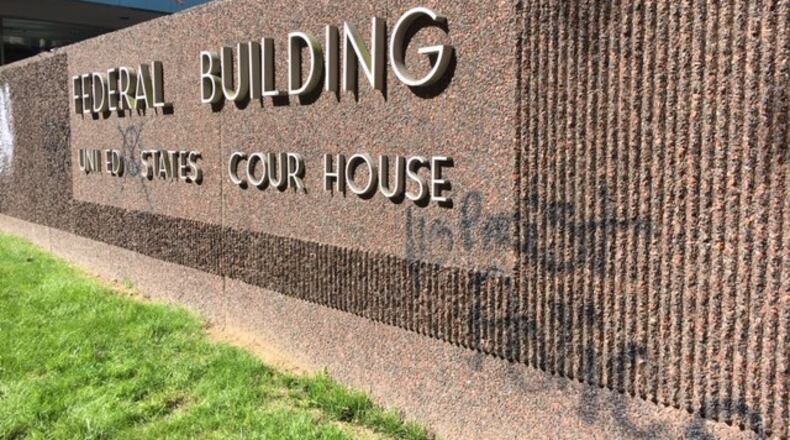 Graffiti on a federal building sign on Wilkinson and Second streets. THOMAS GNAU/STAFF