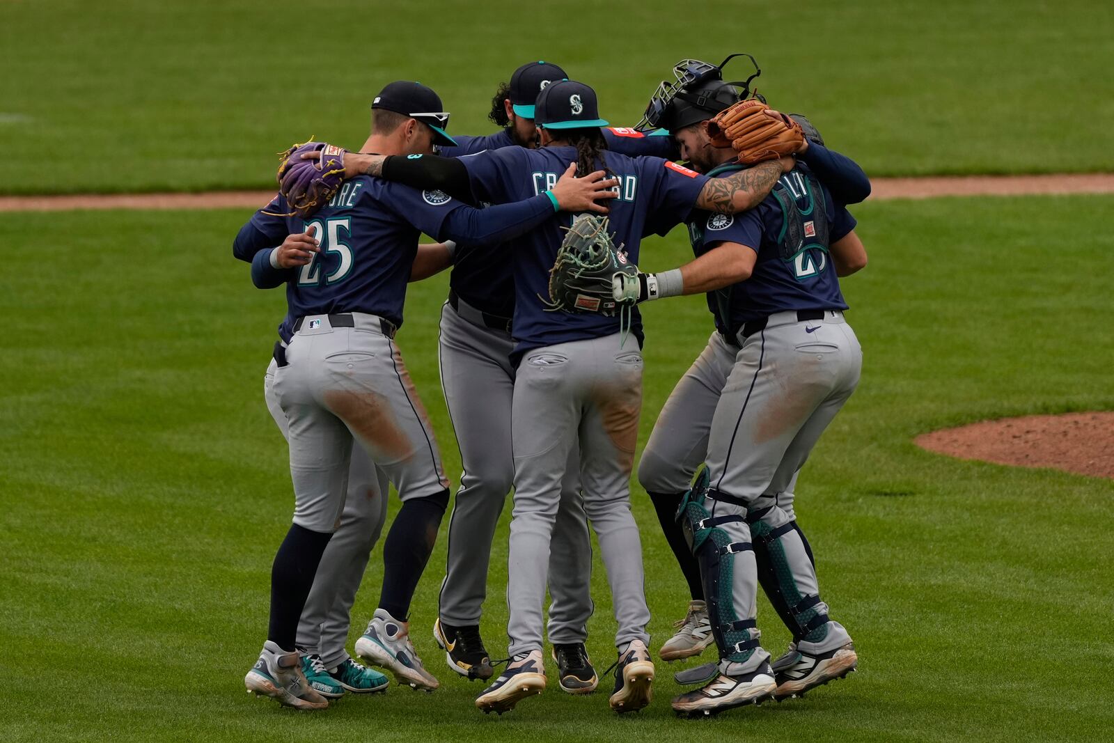 Seattle Mariners players celebrate in the outfield after winning a baseball game against the Cincinnati Reds, Thursday, April 17, 2025, in Cincinnati. (AP Photo/Carolyn Kaster)