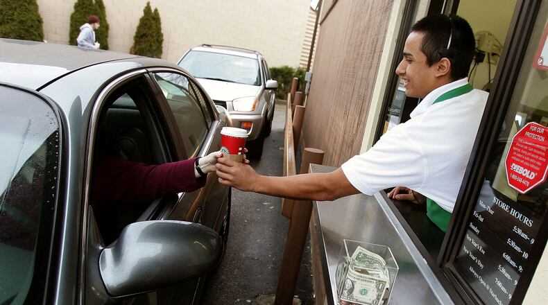 WHEELING, IL - DECEMBER 28:  Starbucks worker Freddie Arteaga assists a customer with her drink order at a Starbucks drive-thru December 28, 2005 in Wheeling, Illinois. Starbucks opened 354 drive-thru stores in the U.S. in the past year, which brought for the first time, the number of new drive-thrus to comprise more than half of all new Starbucks company operated stores opened nationwide.  (Photo by Tim Boyle/Getty Images)