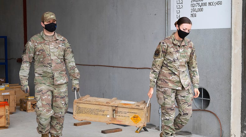 Senior Airman Ryan Klingbeil and Staff Sgt. Jacklyn Hill, 88th Operations Support Squadron Munitions Flight inspectors, carry an explosives crate out of a storage igloo Nov. 17 at Wright-Patterson Air Force Base. The 88th Security Forces Squadron’s K-9 unit used the explosives to train its military working dogs. U.S. AIR FORCE PHOTO/R.J. ORIEZ