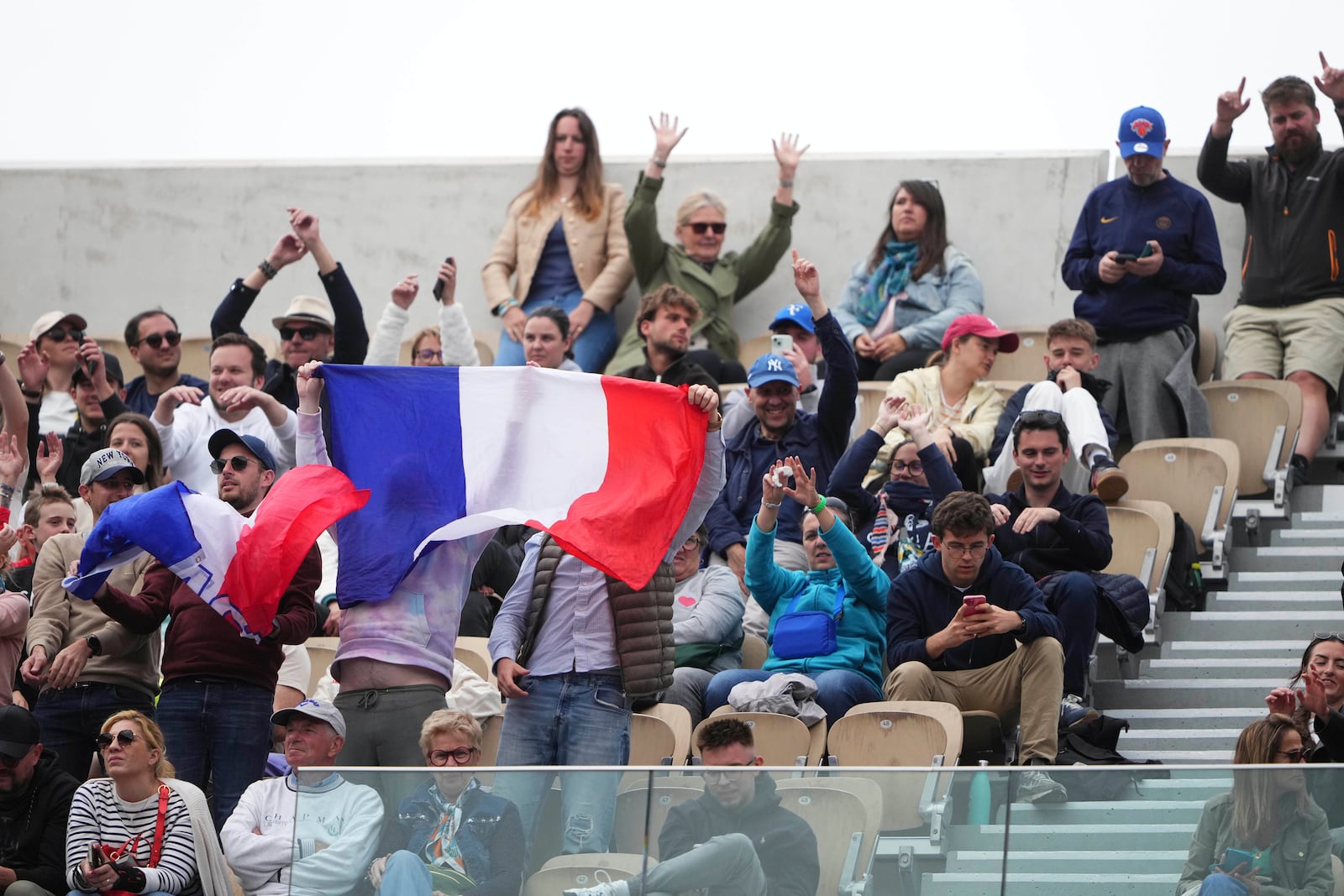 Fans cheer during the first round match of the French Tennis Open between France's Arthur Fils and Chile's Nicolas Jarry, at the Roland-Garros stadium, in Paris, Monday, May 26, 2025. (AP Photo/Lindsey Wasson)