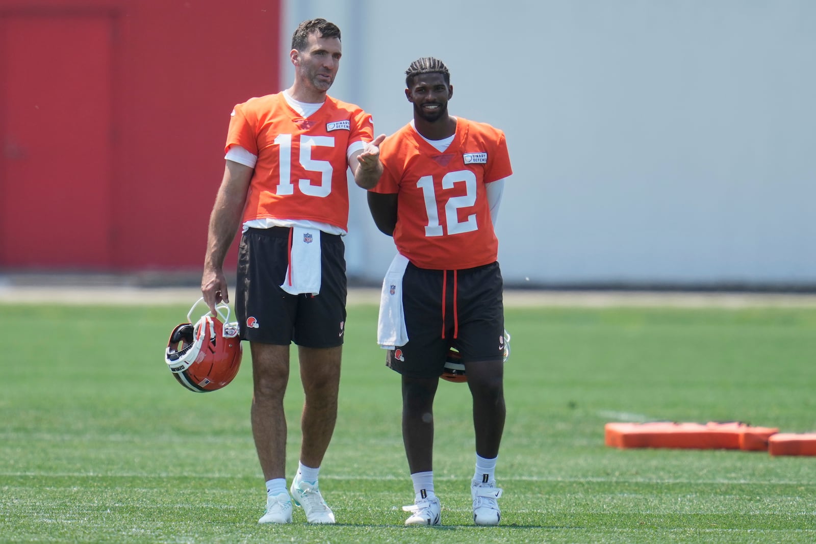 Cleveland Browns quarterbacks Joe Flacco (15) and Shedeur Sanders (12) talk during practice at NFL football minicamp in Berea, Ohio, Wednesday, June 11, 2025. (AP Photo/Sue Ogrocki)