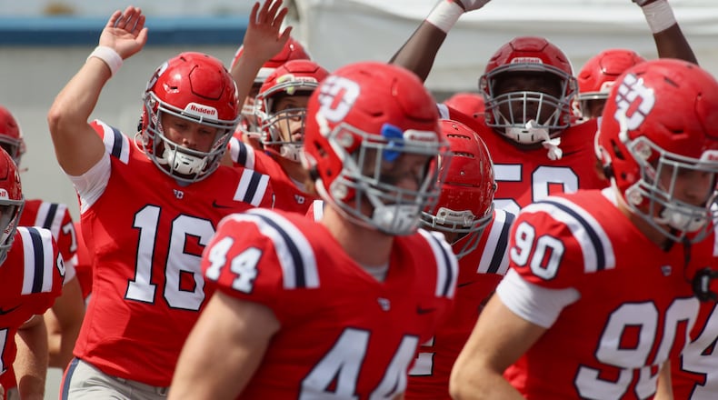 Dayton players run onto the field before a game against Central State on Saturday, Sept. 9, 2023, at Welcome Stadium. David Jablonski/Staff