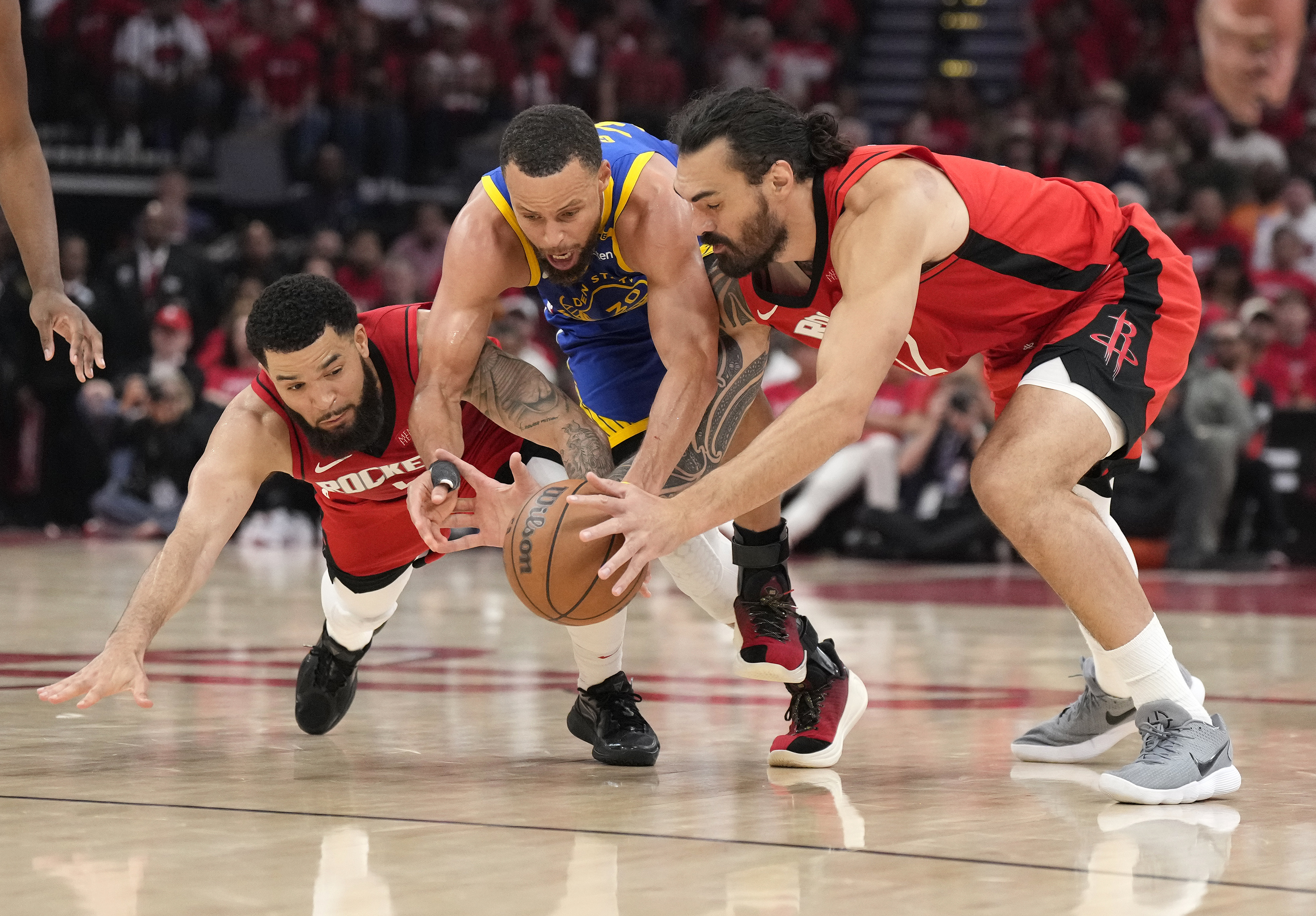 Golden State Warriors guard Stephen Curry, center, fights for a loose ball with Houston Rockets guard Fred VanVleet, left, and Rockets center Steven Adams during the second half of Game 2 of an NBA basketball first-round playoff series against the Houston Rockets in Houston, Wednesday, April 23, 2025. (AP Photo/Karen Warren)