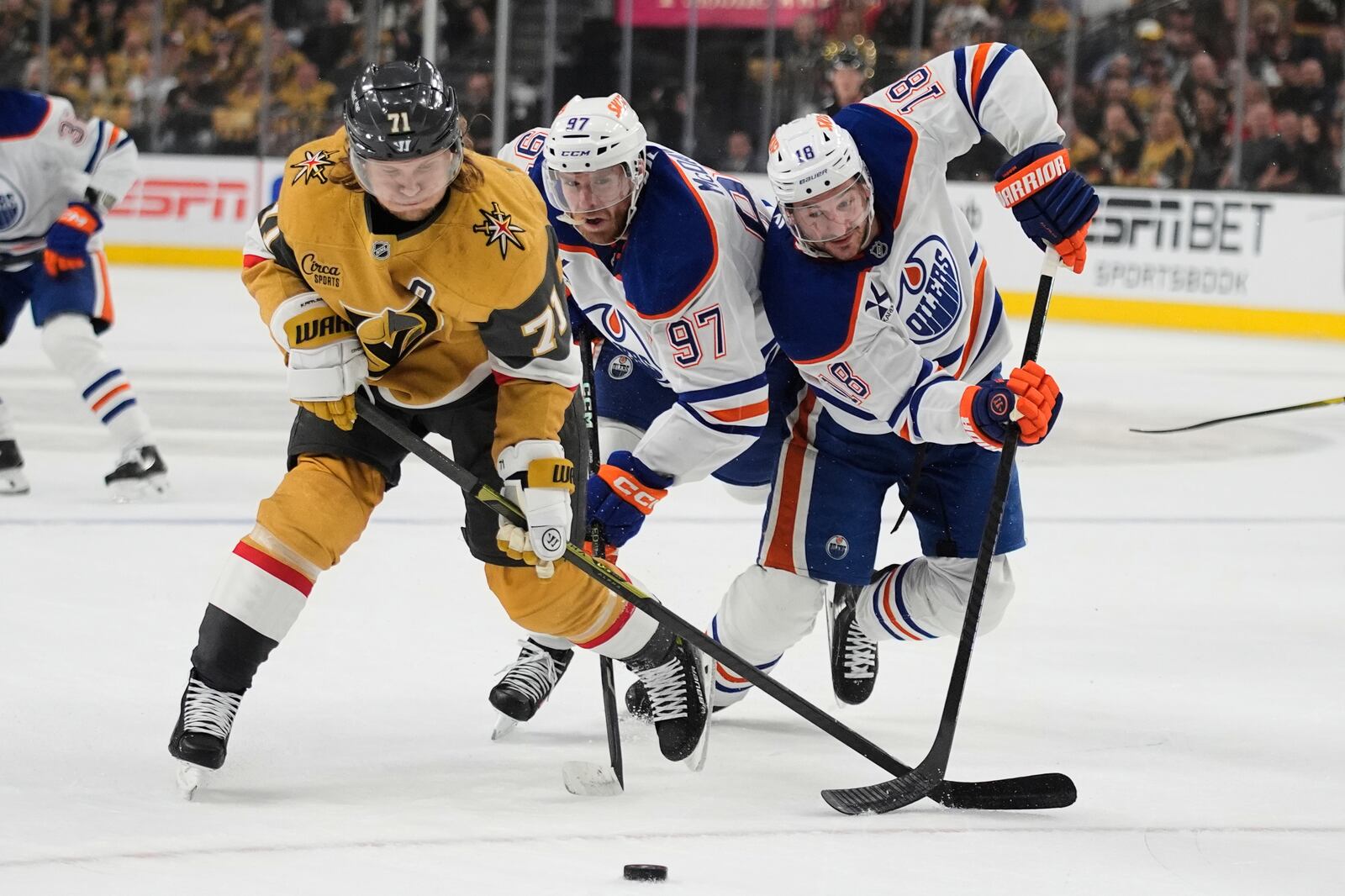 Vegas Golden Knights center William Karlsson (71), Edmonton Oilers center Connor McDavid (97) and Edmonton Oilers left wing Zach Hyman (18) vie for the puck during the first period of Game 2 of a second-round NHL hockey playoff series Thursday, May 8, 2025, in Las Vegas. (AP Photo/John Locher)